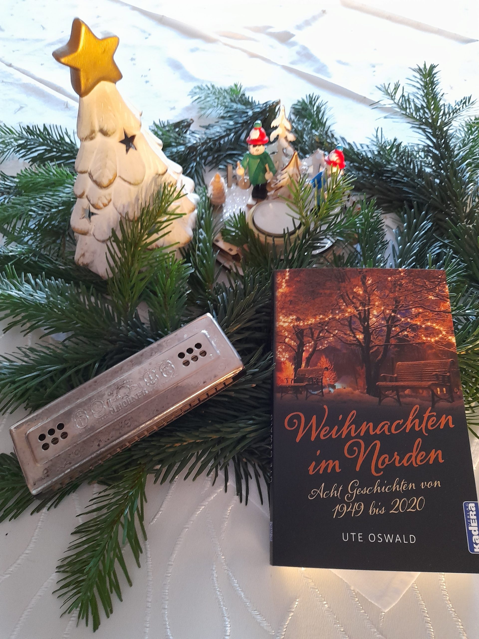 Mundharmonika mit Buch "Weihnachten im Norden" auf Tannenzweigen